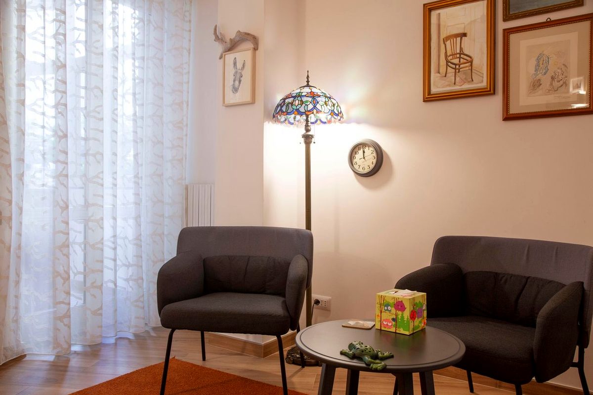 Angolo dello studio con lampada Tiffany, poltrone e tavolino